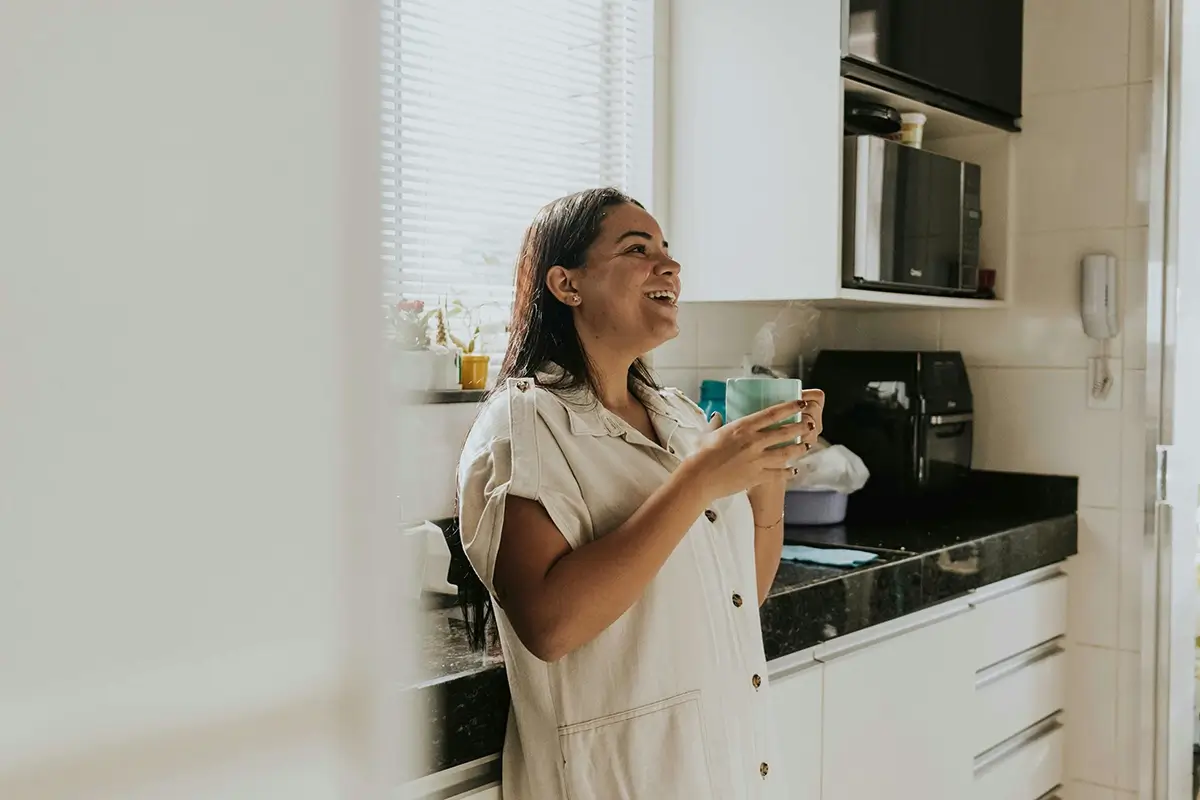 Woman in perimenopause having morning coffee in kitchen
