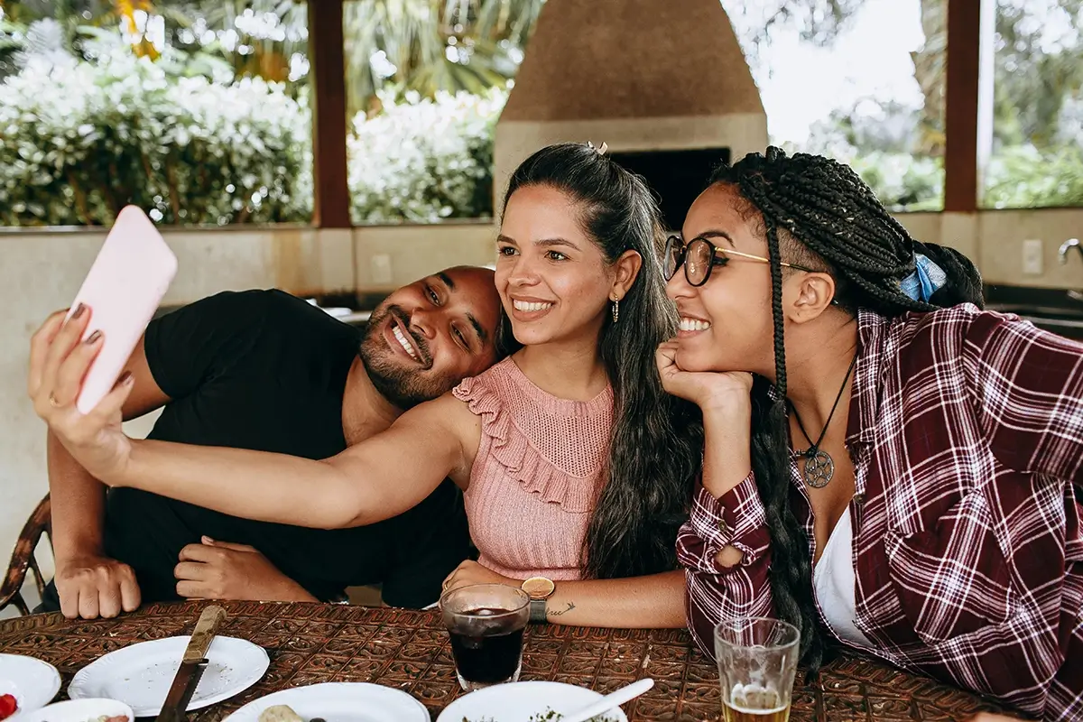group of friends taking selfie over dinner