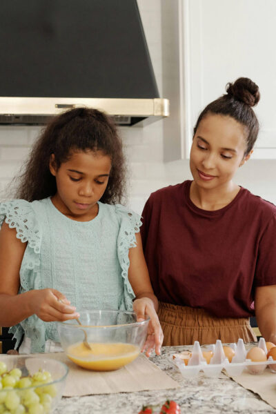 Mom and daughter mixing batter in kitchen