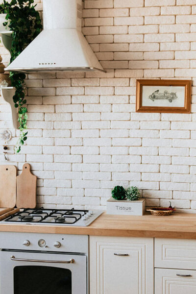 white kitchen with brick walls and cabinets