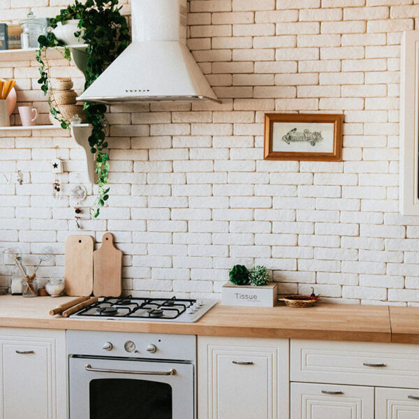 white kitchen with brick walls and cabinets